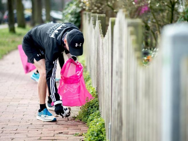 image of a person picking up thrash during their jog